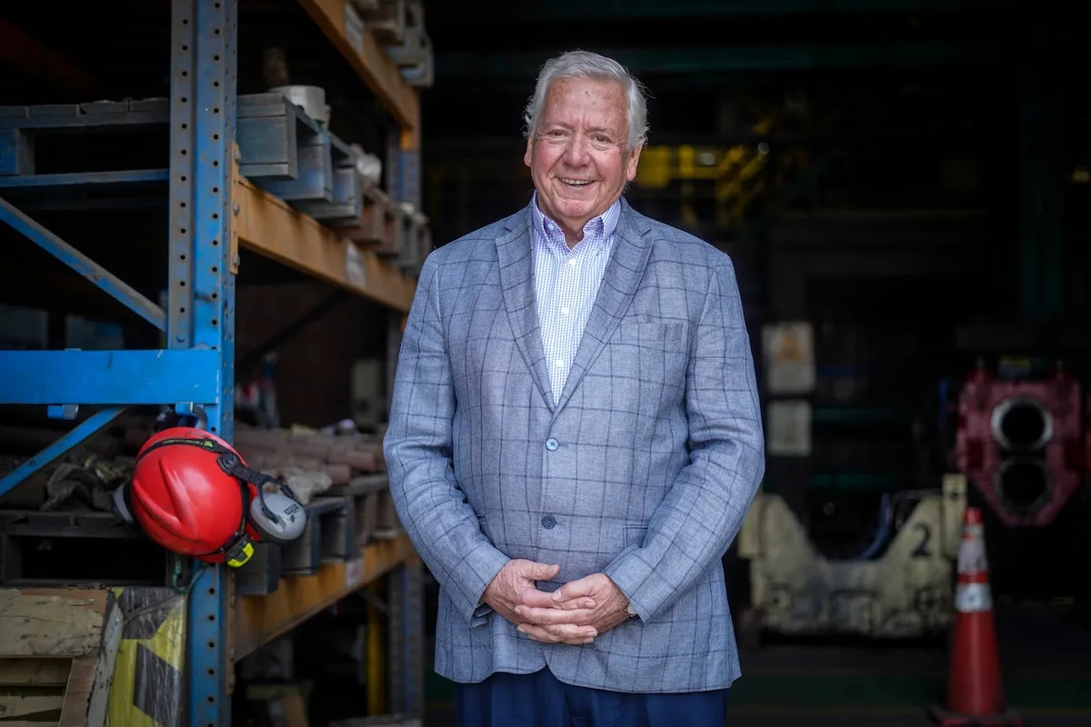 Gráfico del mercado del acero en Chile con edificios en construcción y una persona revisando sus finanzas.
