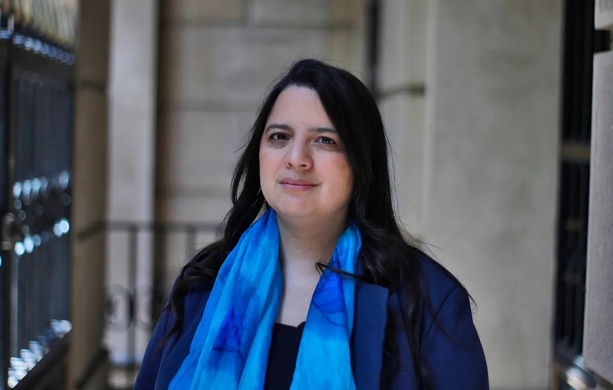 Mano sosteniendo billetes chilenos con un gráfico de estabilidad económica de fondo, simbolizando el impacto del presupuesto aprobado.